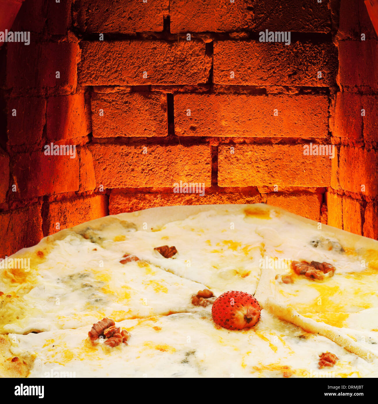 italian pizza quatro formaggi and hot brick wall of wood burning oven Stock Photo