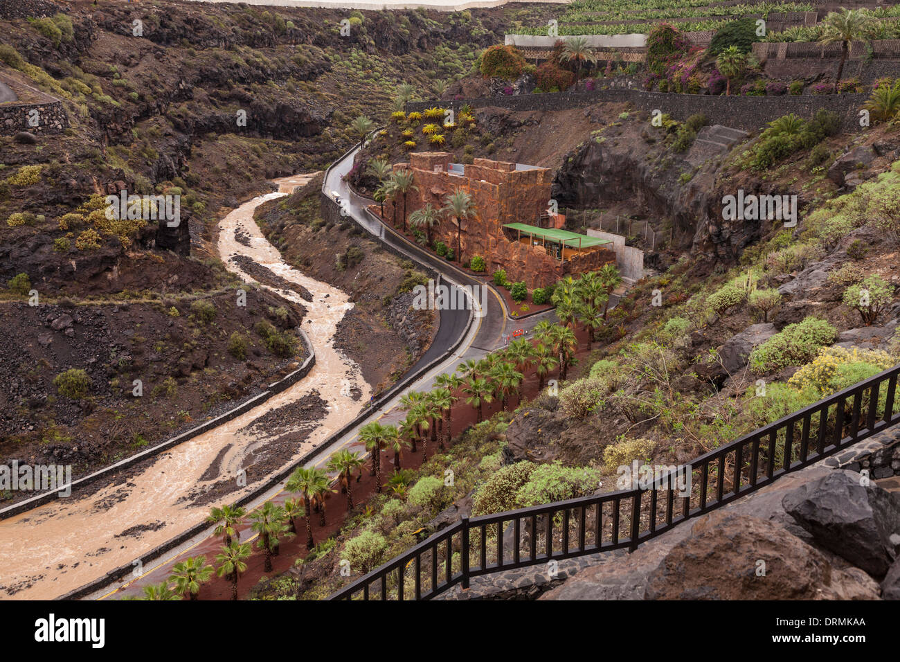 Water flowing down the barranco at Abama 5 star resort after recent rains. Desalination plant in redish building on the right. Stock Photo