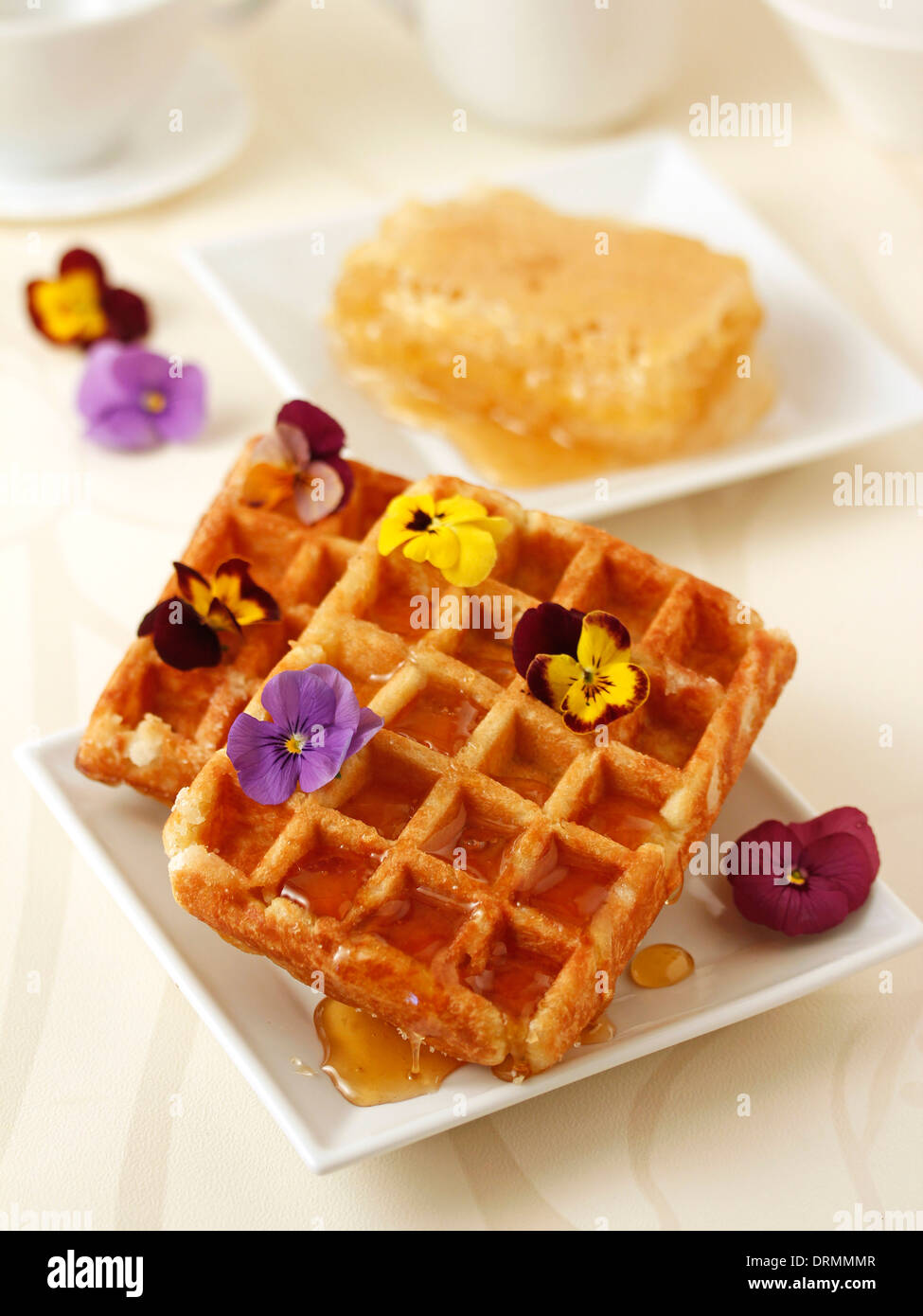 Waffles with honey and flowers. Recipe available. Stock Photo