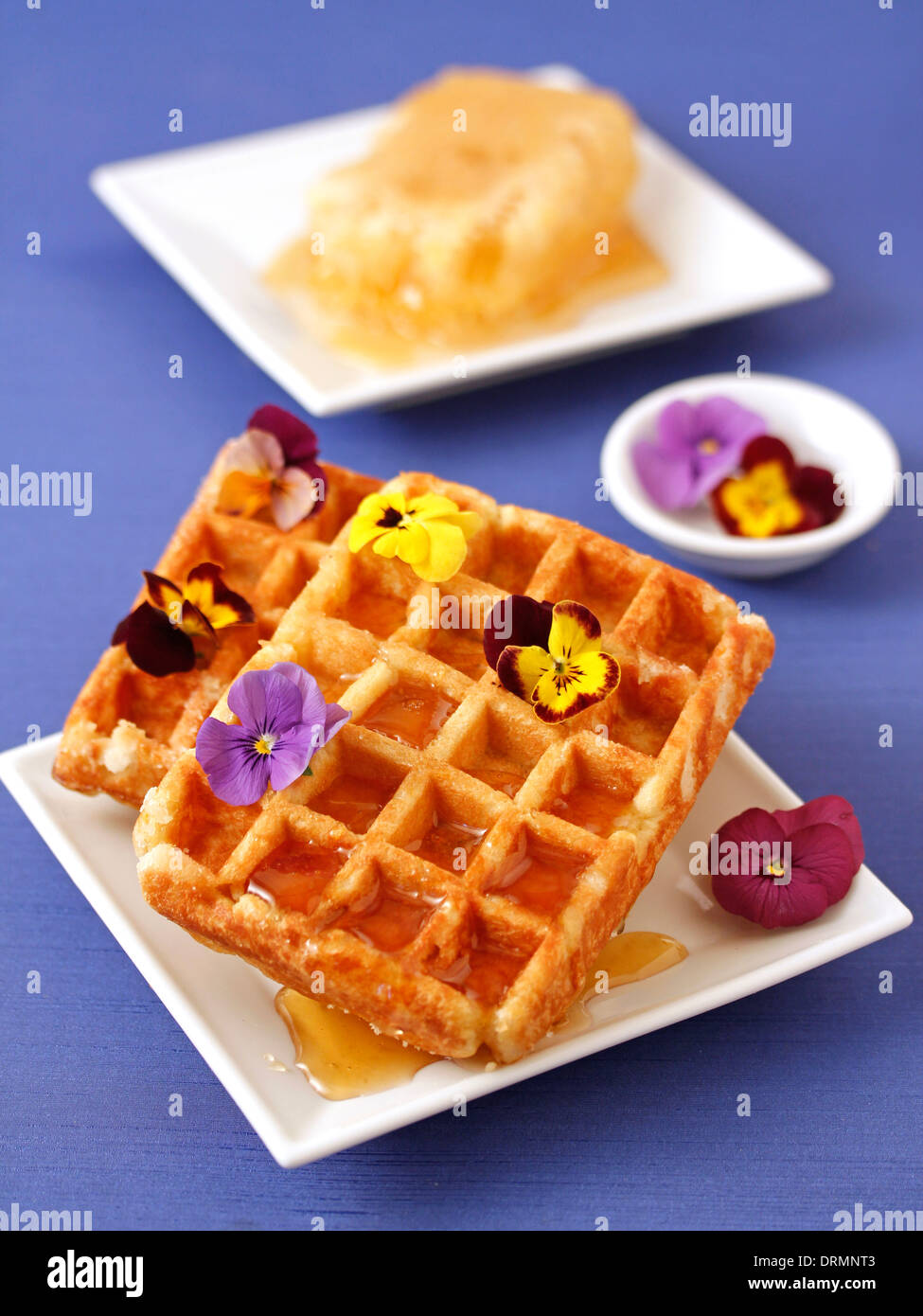 Waffles with honey and flowers. Recipe available. Stock Photo