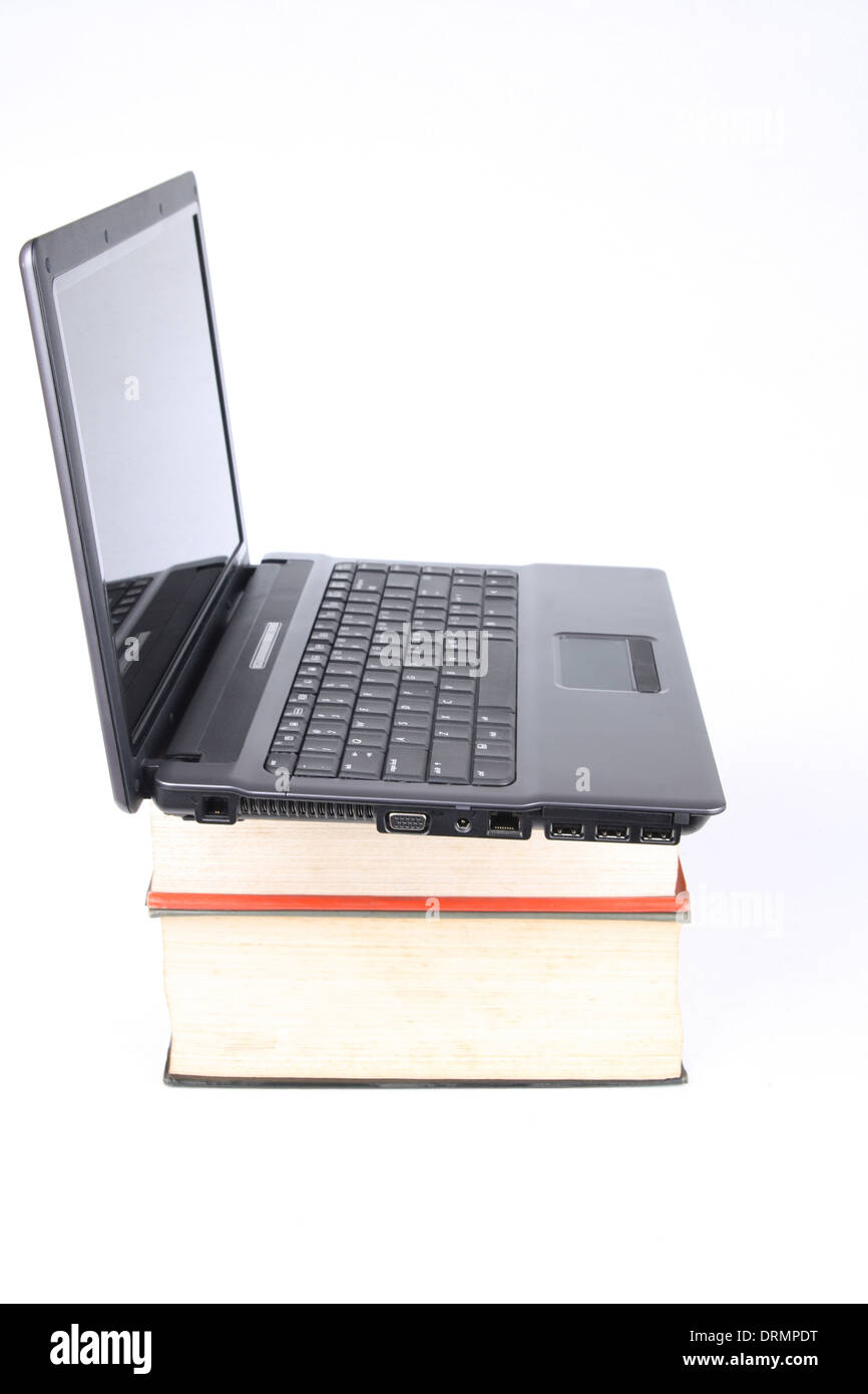 a laptop computers on thick of books Stock Photo