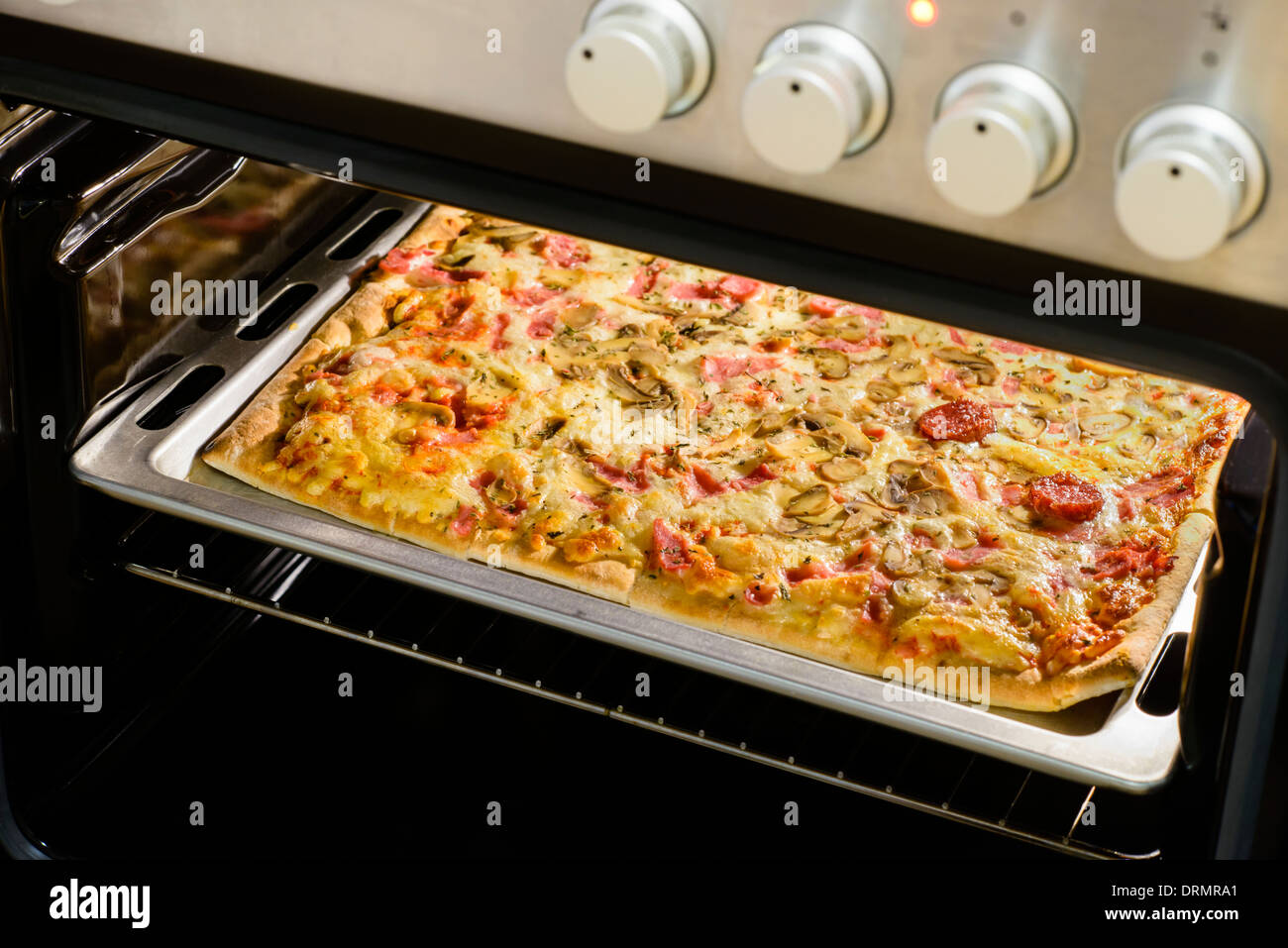 Homemade pepperoni pizza in oven Stock Photo