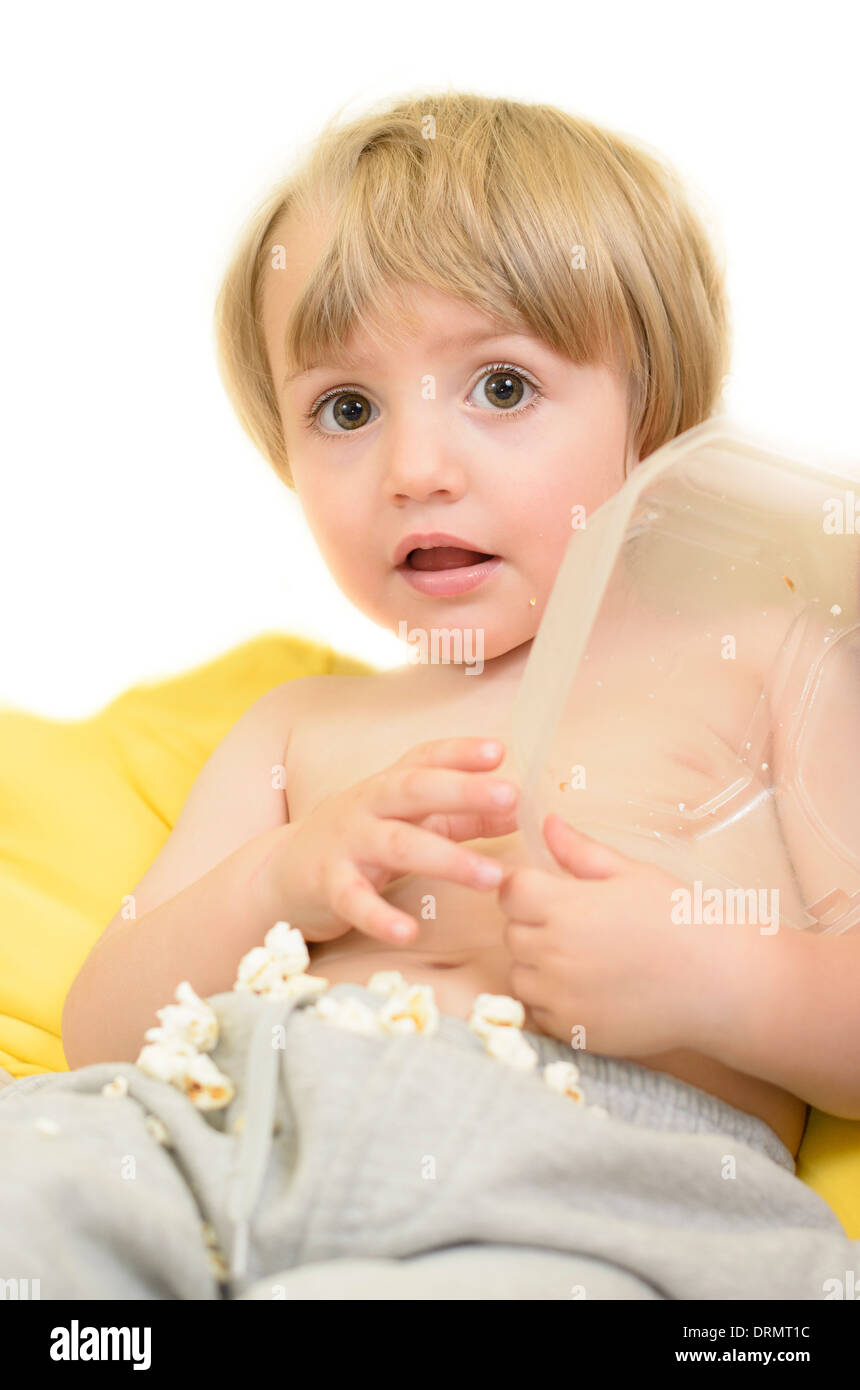 Astonished kid eating popcorn Stock Photo