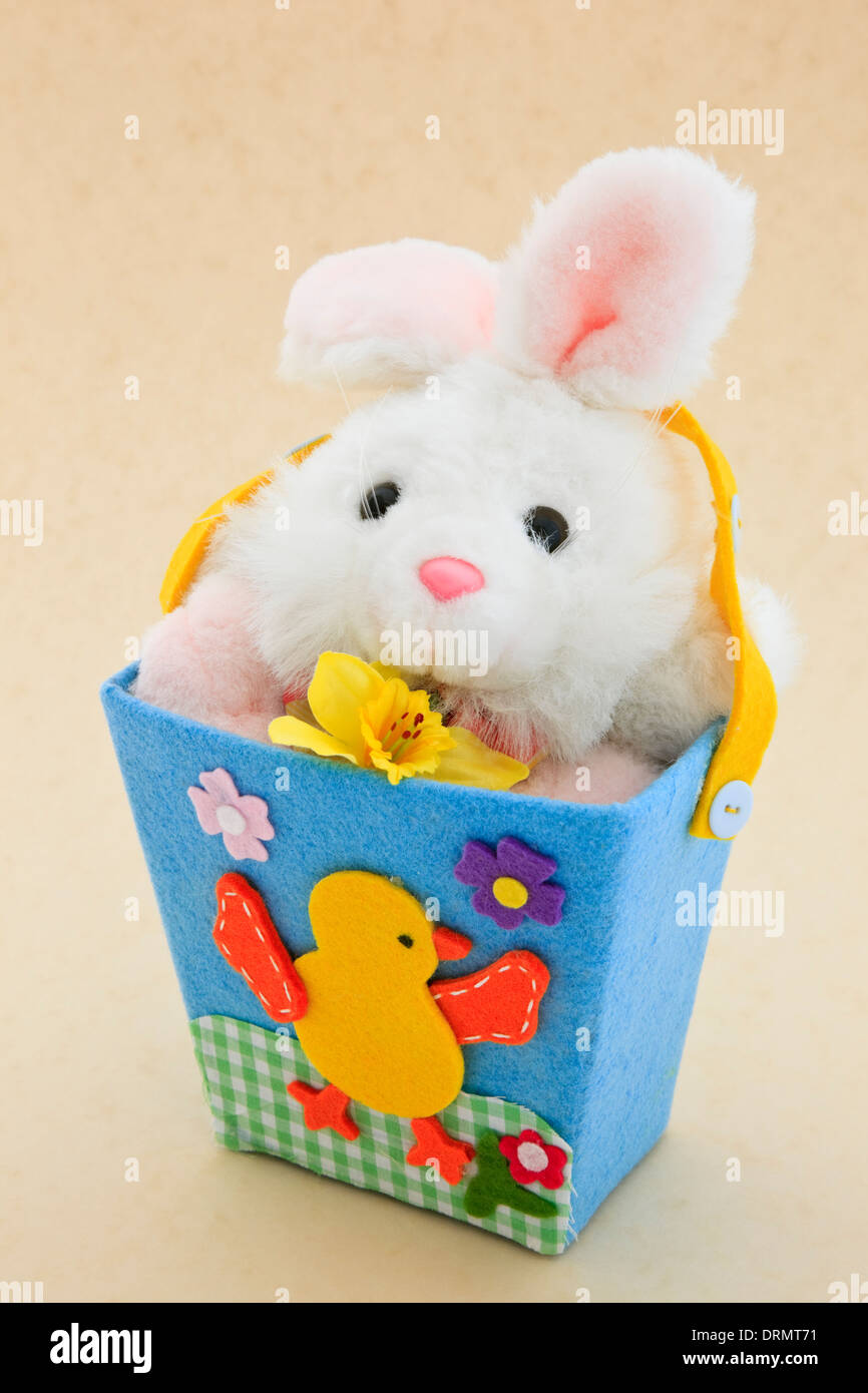 Soft fluffy cute Easter bunny child's toy in a bucket Stock Photo