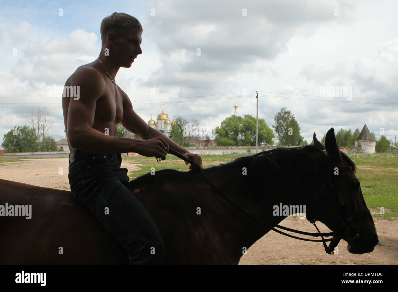 Riding instructor and horse keeper rides a horse in Mozhaysk, Russia