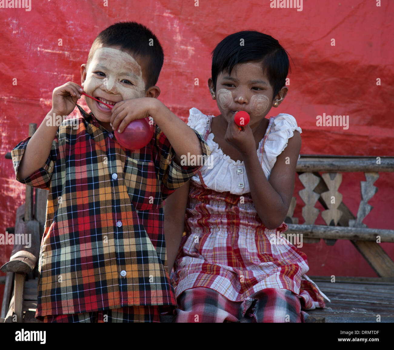 Two kids playing with balloons Bagan during the Ananda temple Festival Stock Photo