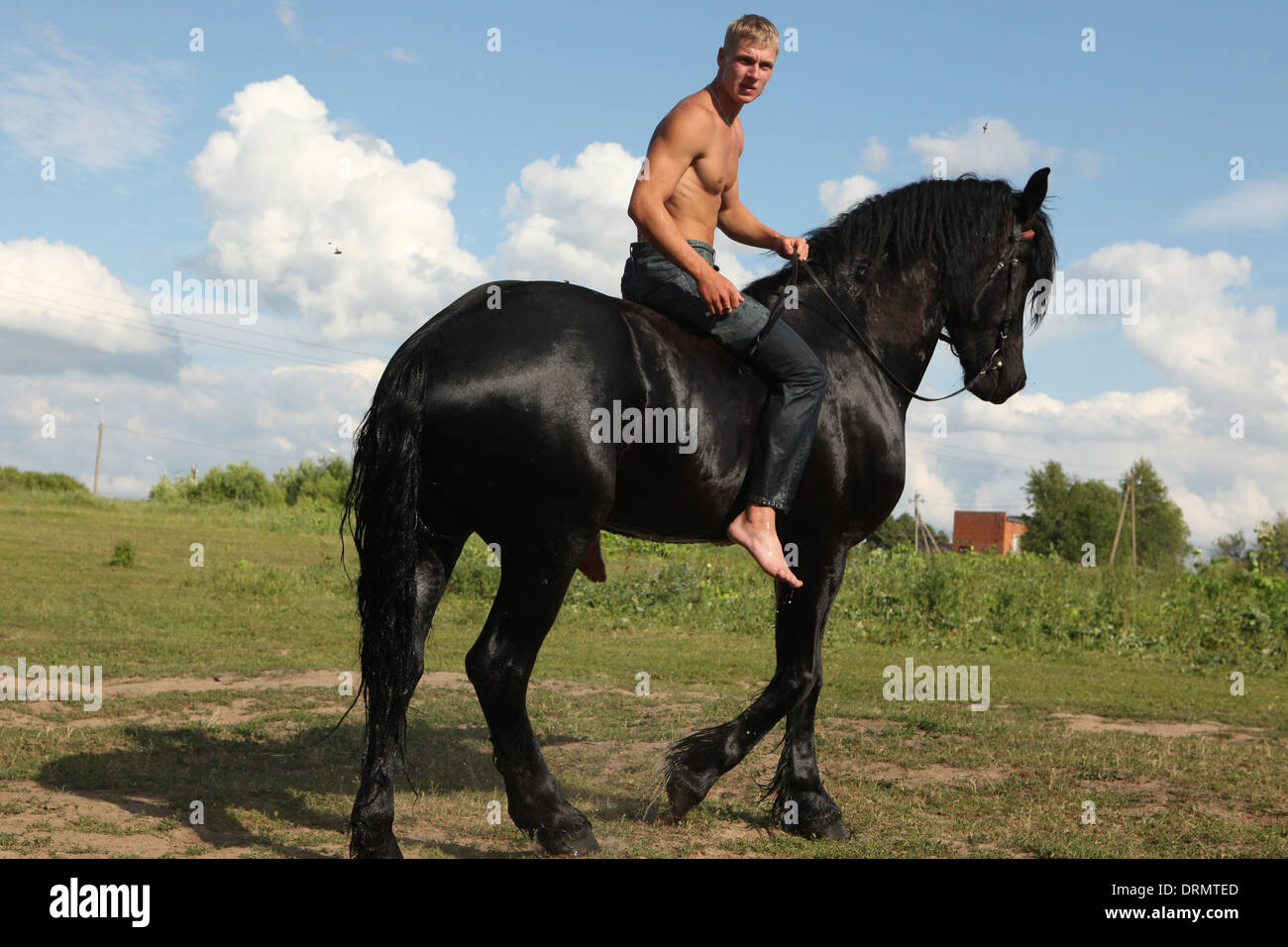 Riding instructor and horse keeper Dmitry Novikov rides a horse near