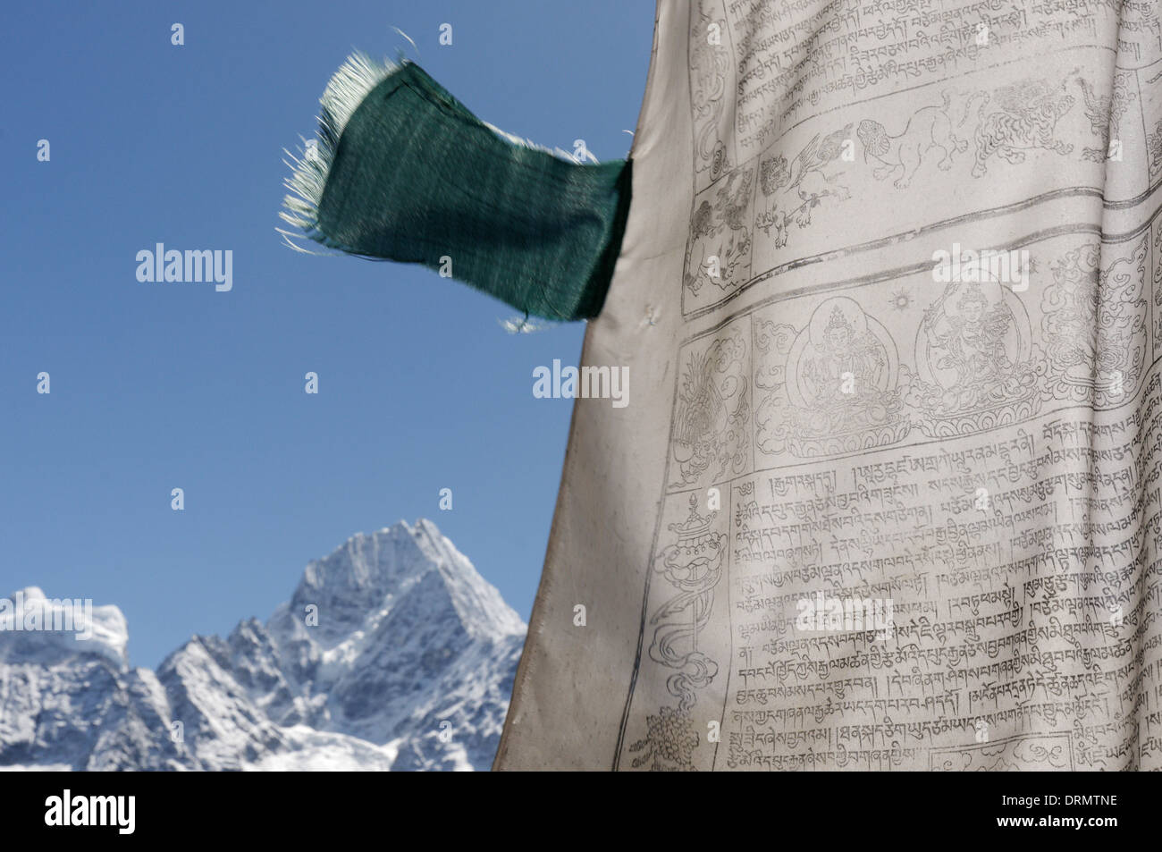 A prayer flag in the village of Khumjung on the everest base camp trek with Kantega beyond Stock Photo