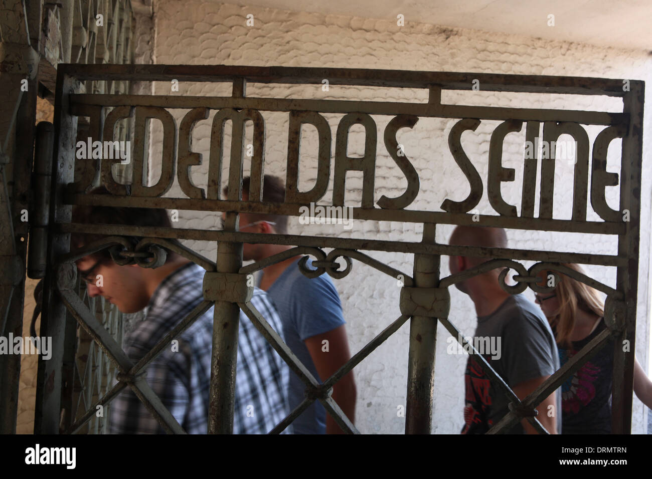 Jedem das Seine. Visitors pass the main gate of Buchenwald concentration camp near Weimar, Germany. Stock Photo