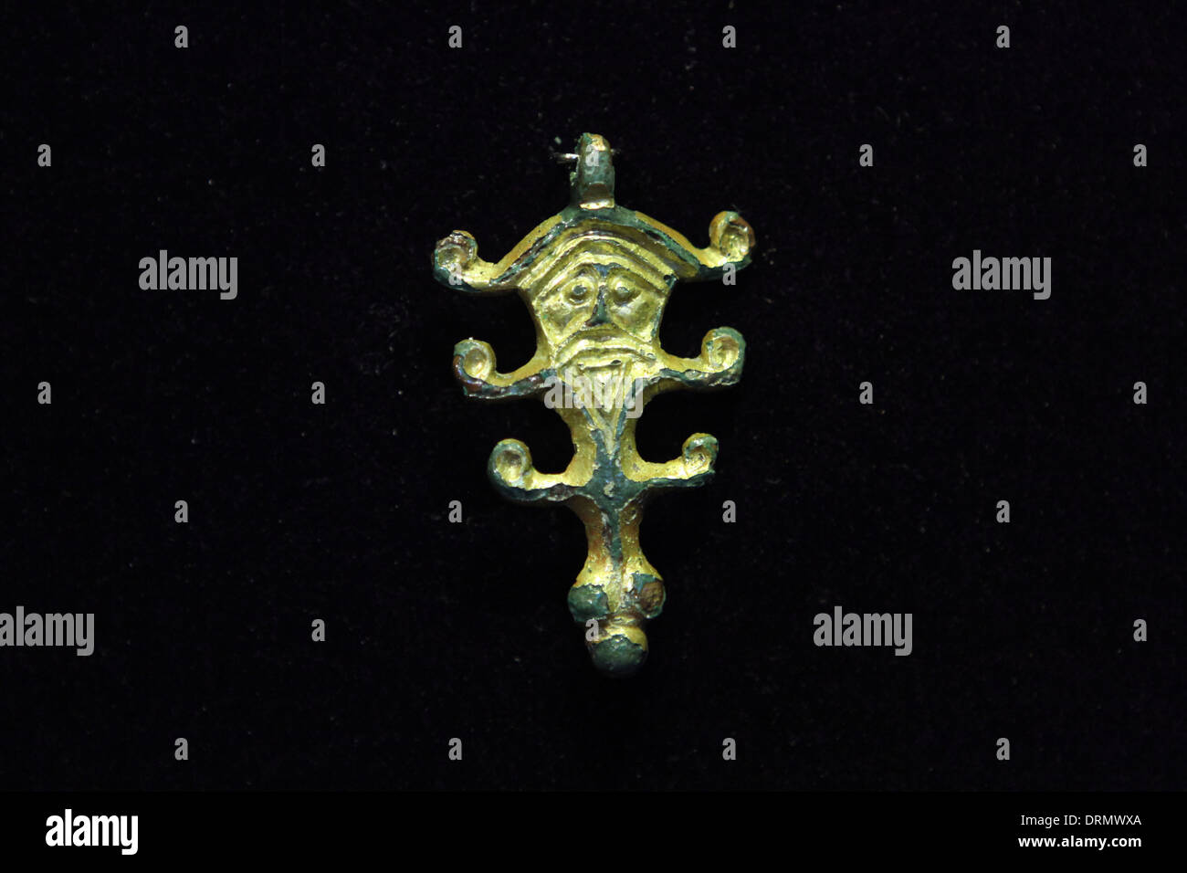 Great Moravian Empire. Gilt bronze pendant with a human face and horns, symbol of Slavic pagan god Veles, from the 8th century. Stock Photo