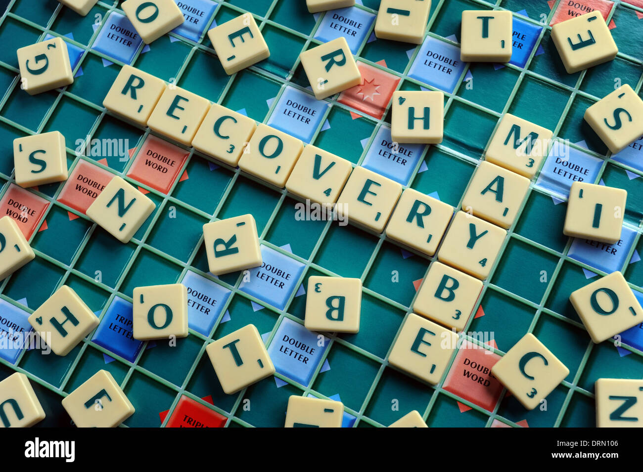 WORDS TILES SPELLING RECOVERY MAYBE RE THE ECONOMY MONEY SAVINGS INCOMES HOUSEHOLD BUDGETS FAMILY WAGES RECESSION CASH  UK Stock Photo