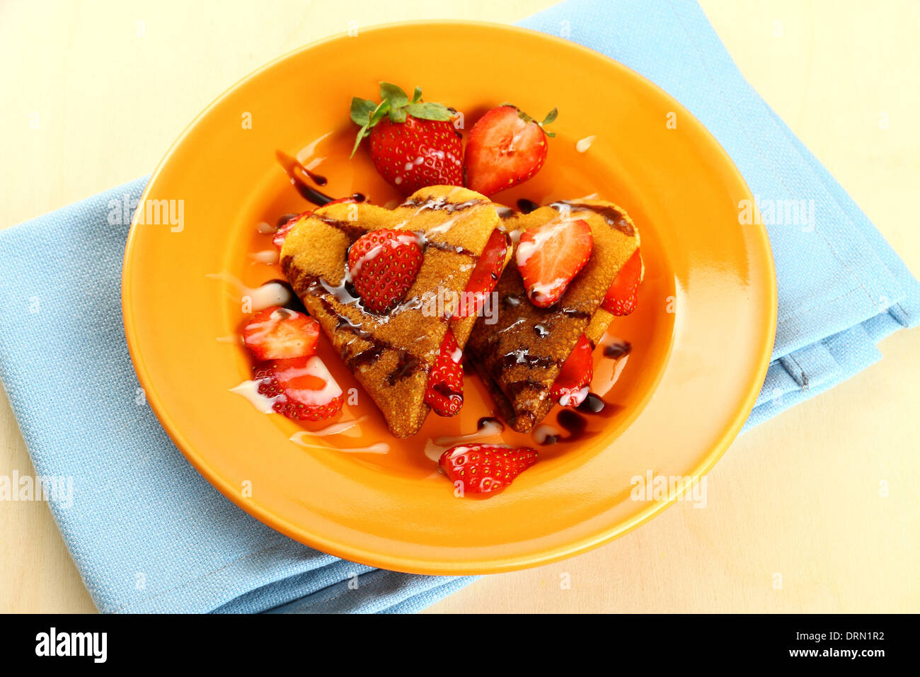 Two pancakes hearts with strawberry, chocolate, sugar milk Stock Photo