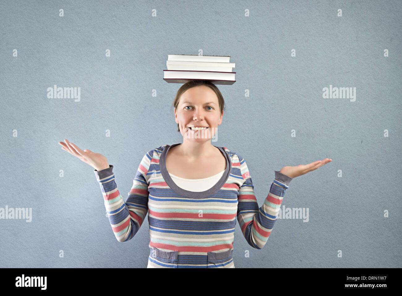 Smiling student with books on her head Stock Photo - Alamy