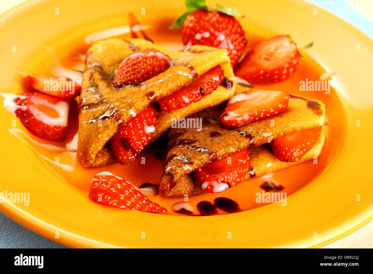 Two pancakes hearts with strawberry, chocolate, sugar milk, close up Stock Photo