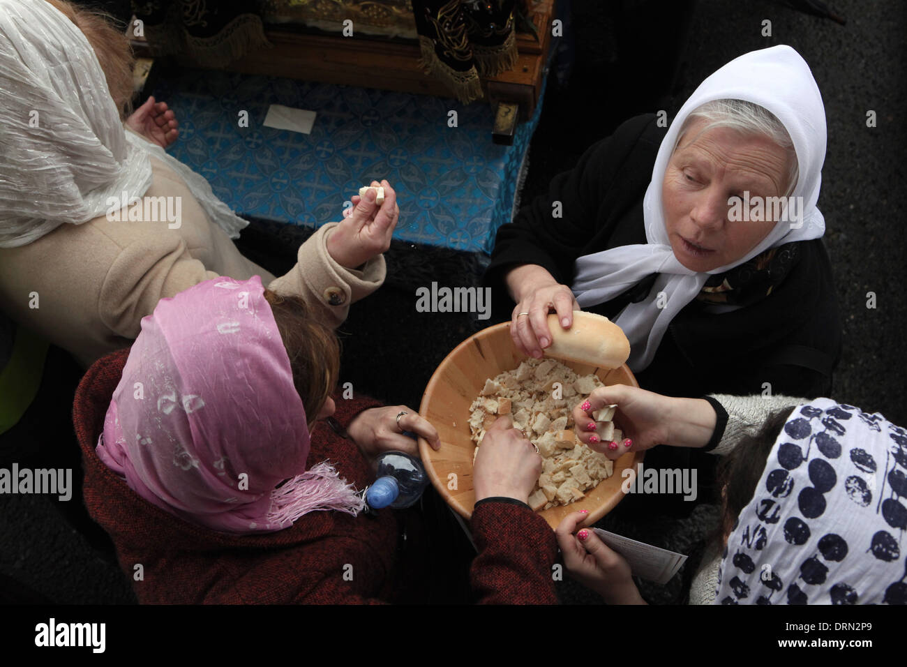 Orthodox believers take the lambs, square portions of bread cut from the prosphora. Stock Photo