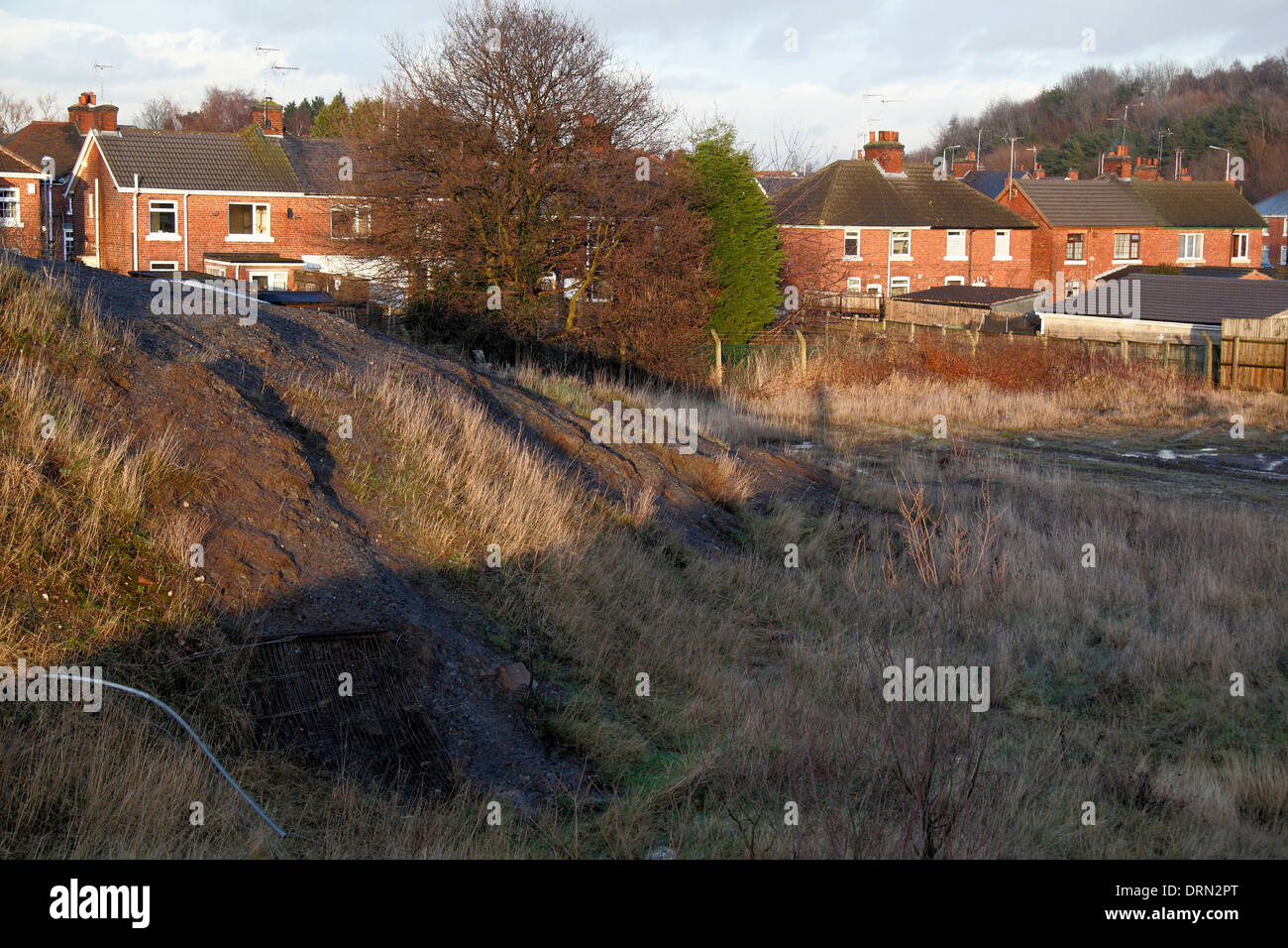 What appears to be spoils on the former site of Ollerton Colliery adjacent residential housing, New Ollerton,Nottinghamshire, UK Stock Photo