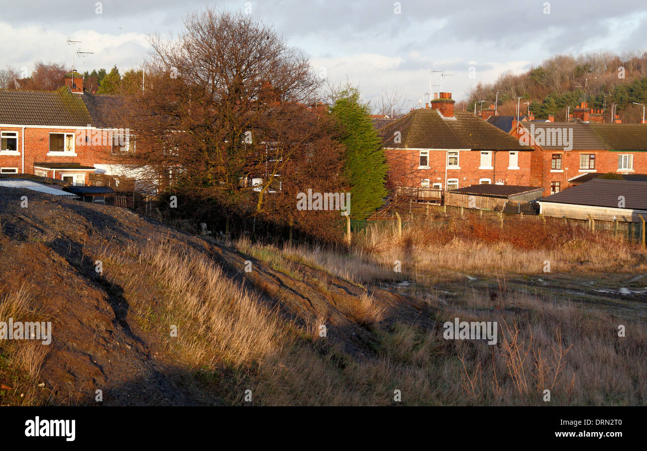 What appears to be spoils on the former site of Ollerton Colliery adjacent residential housing, New Ollerton,Nottinghamshire, UK Stock Photo