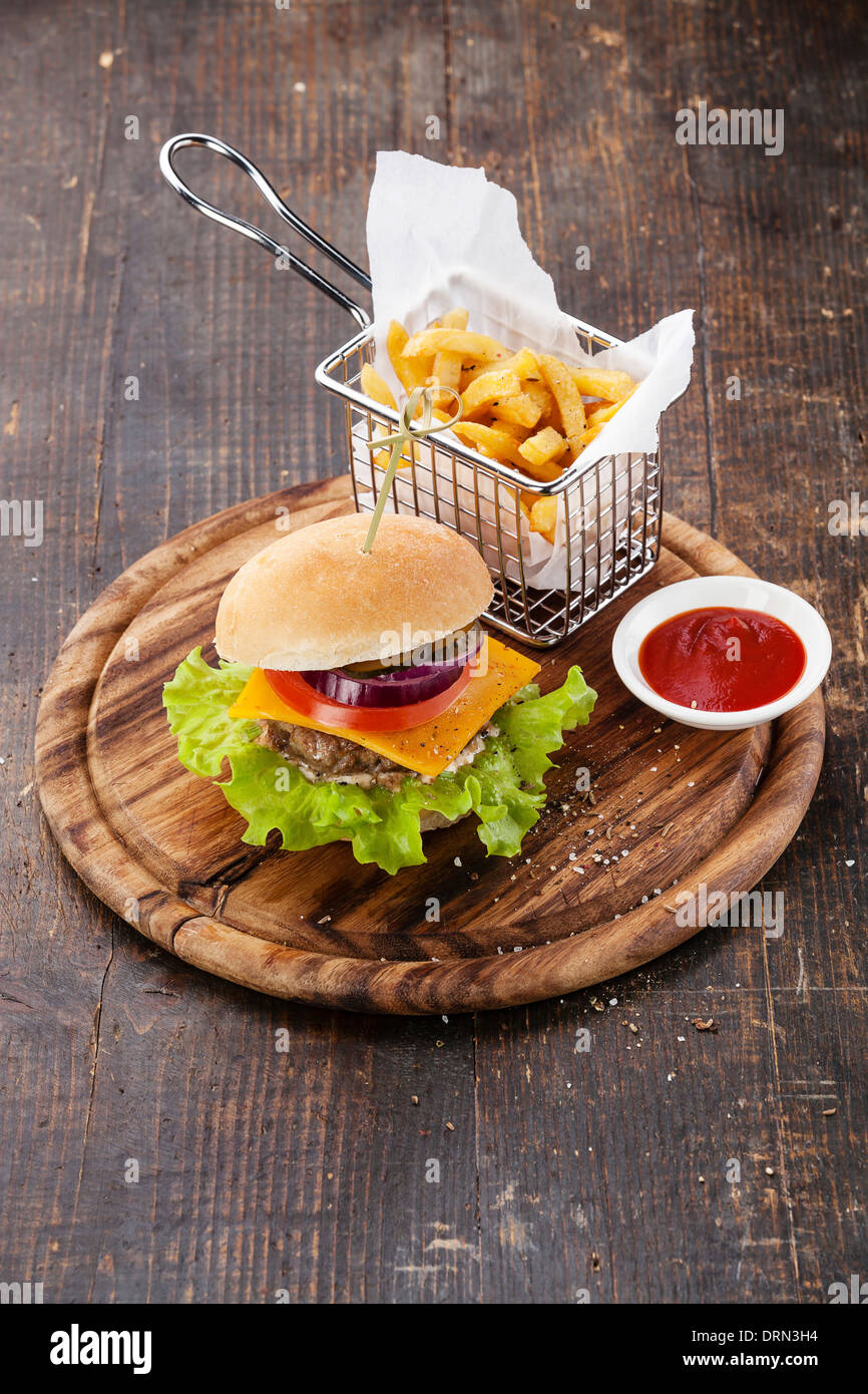 Burger and French fries in basket on wooden background Stock Photo ...