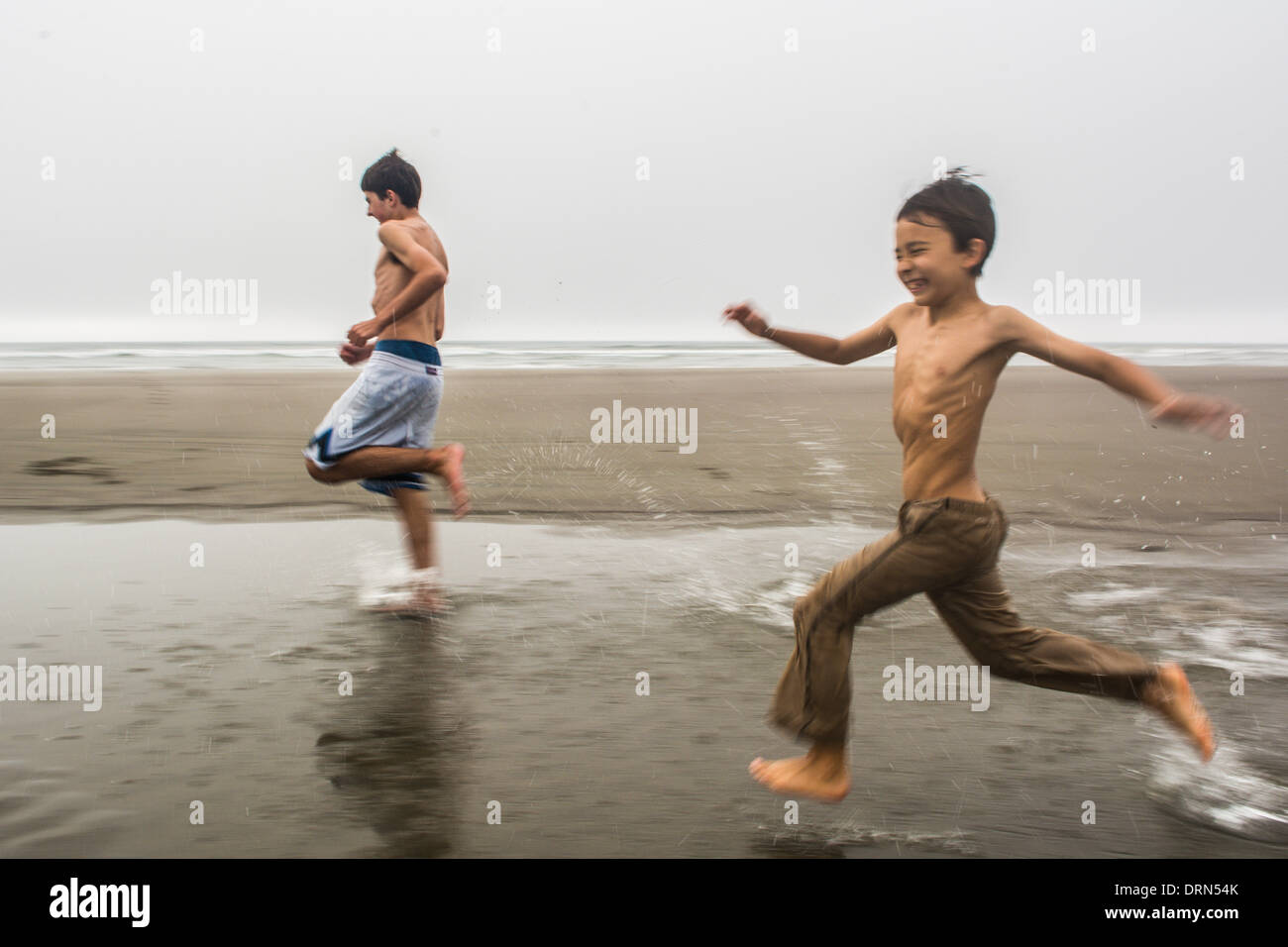 Boys running through water beach hi-res stock photography and images - Alamy