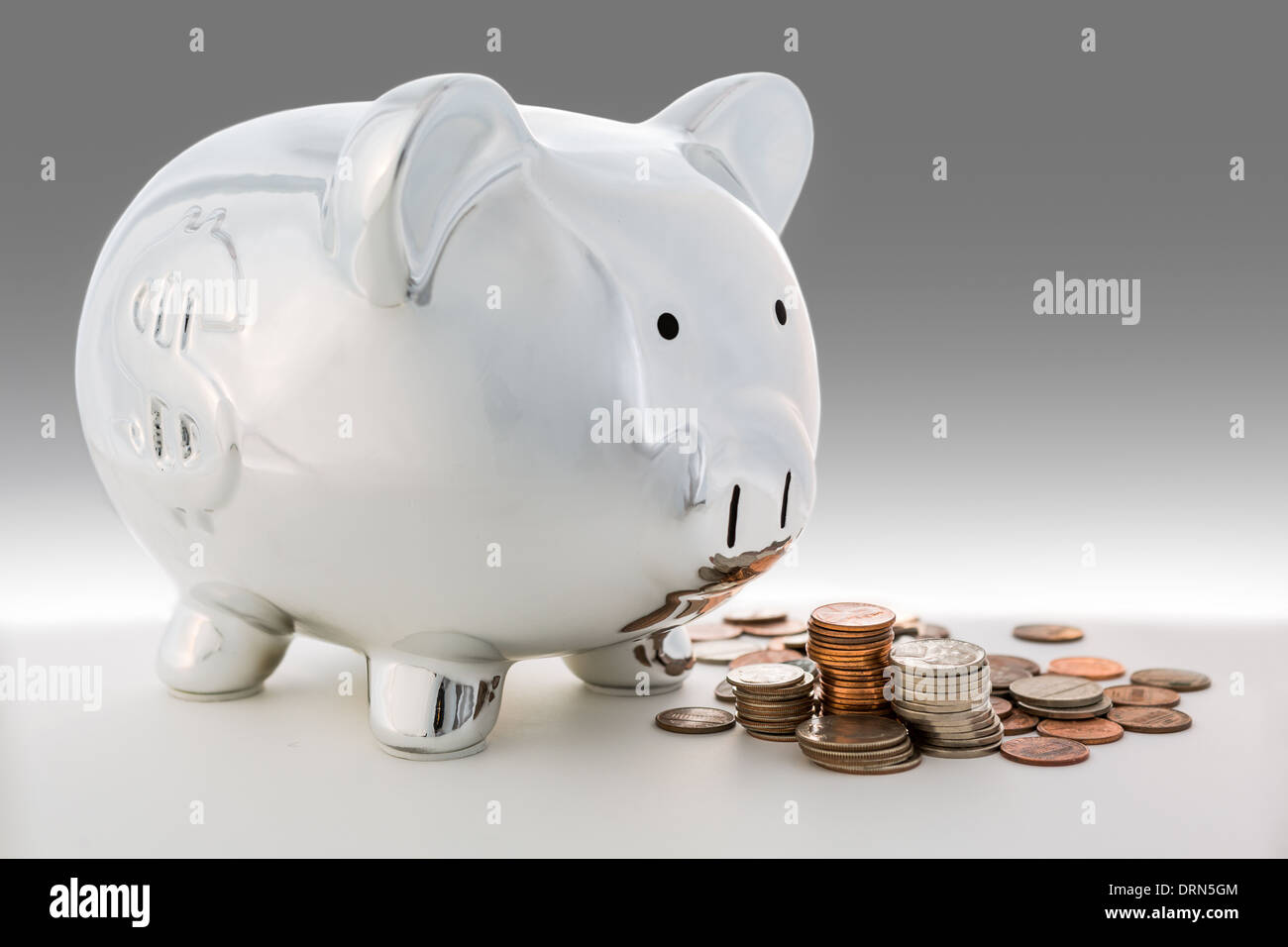 Piggy bank and a pile of coins Stock Photo - Alamy