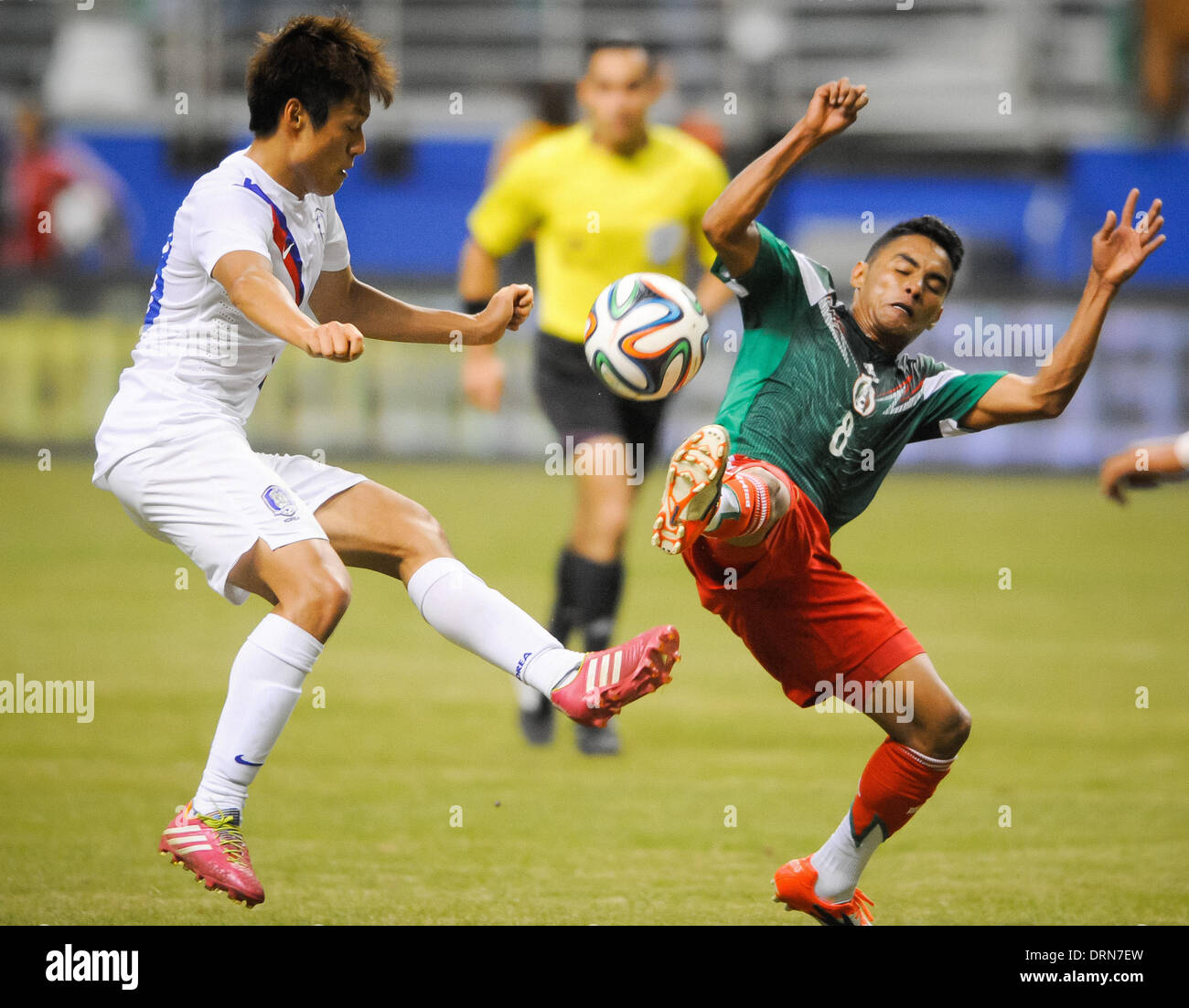 San Antonio, Texas, USA. 29th Jan, 2014. Korea's Lee Myung-Joo, left, and Mexico's Juan Jose Vazquez try to control the ball in the first half. The Mexican national team defeated South Korea 4-0 in an international friendly Wednesday, January 29, 2014 at the Alamodome in San Antonio, Texas. Credit:  Bahram Mark Sobhani/ZUMAPRESS.com/Alamy Live News Stock Photo