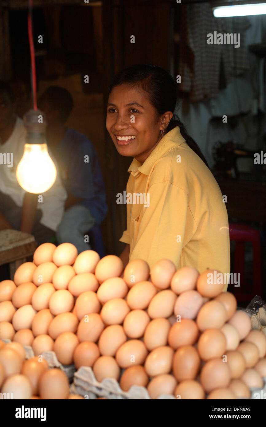 Smiling Indonesian woman selling eggs at market in Kupang, West Timor, Indonesia Nov 2005 Stock Photo