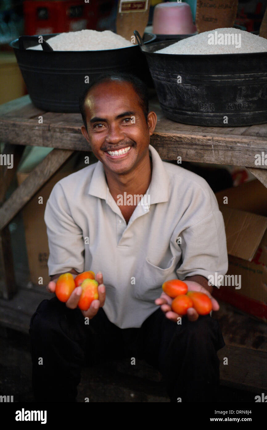 Portrait of smiling Indonesian man holding fruit at a market in Kupang, West Timor, Indonesia Nov 2005 Stock Photo