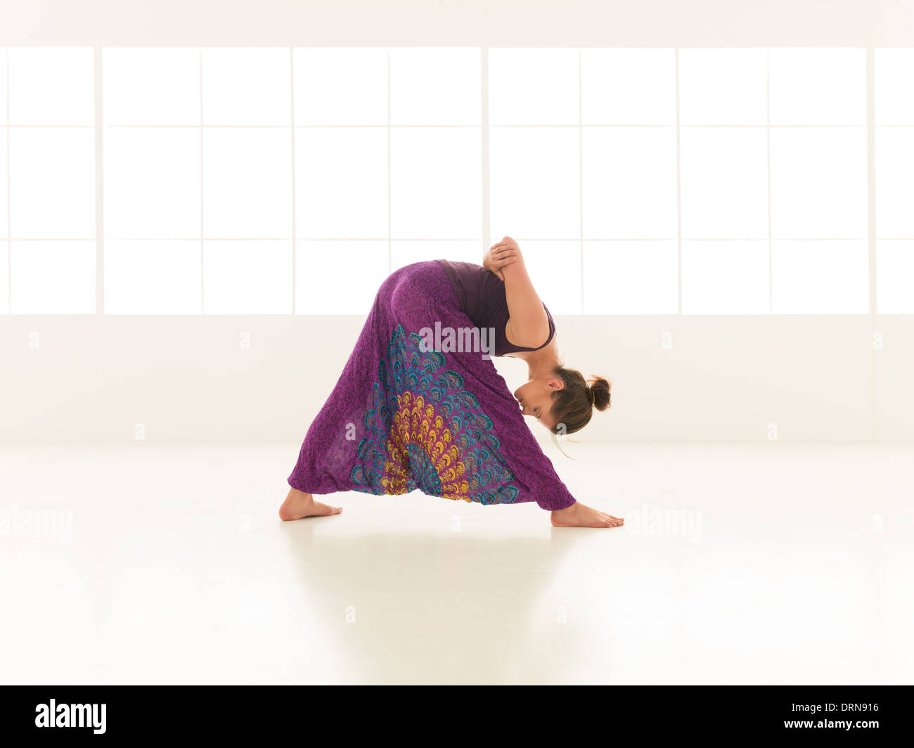 young, woman practicing yoga posture, with face obscured, indor shot Stock Photo