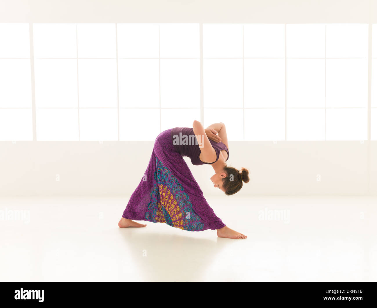 young, woman practicing yoga posture, with face obscured, indor shot Stock Photo