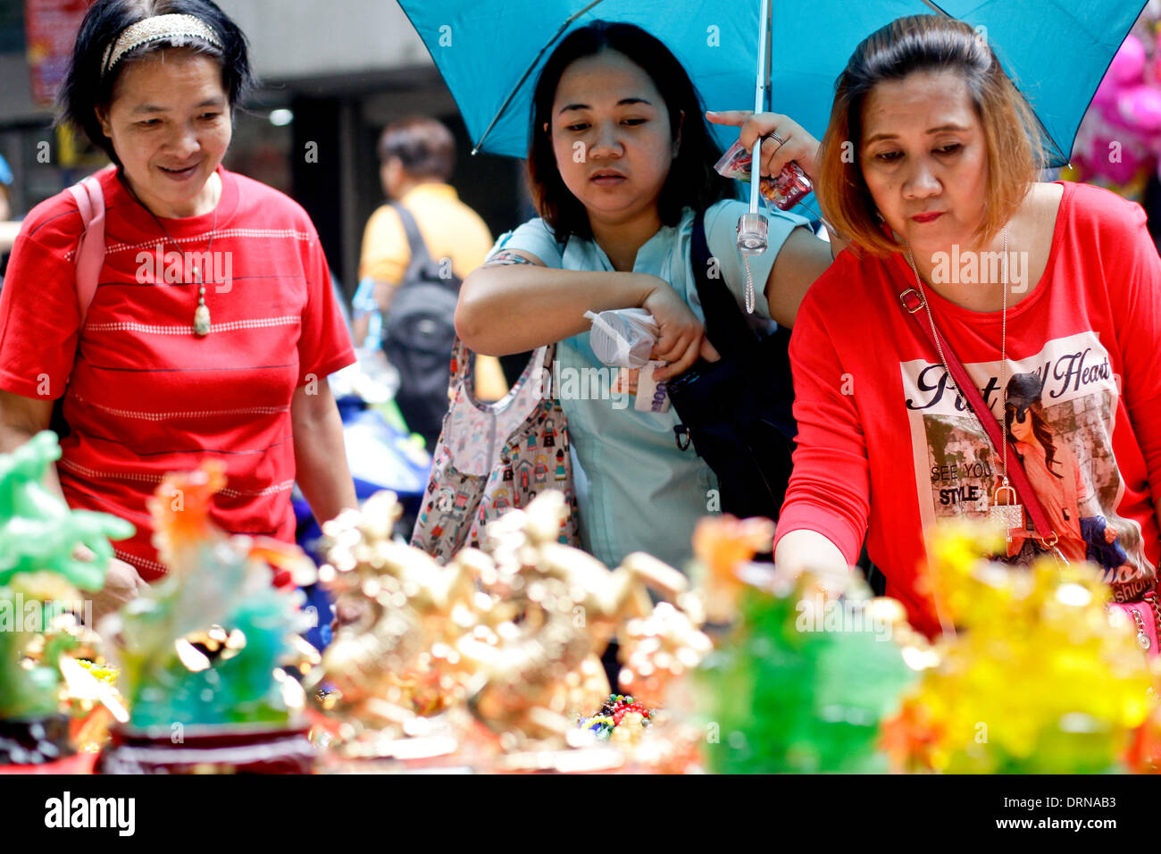Manila, Phillipines. 30th January 2014. A woman shops for lucky charms in Chinatown Manila on January 30, 2014 a day before Chinese New Year, the Year of the Horse. Photo by Mark Cristino/Alamy Live News Stock Photo