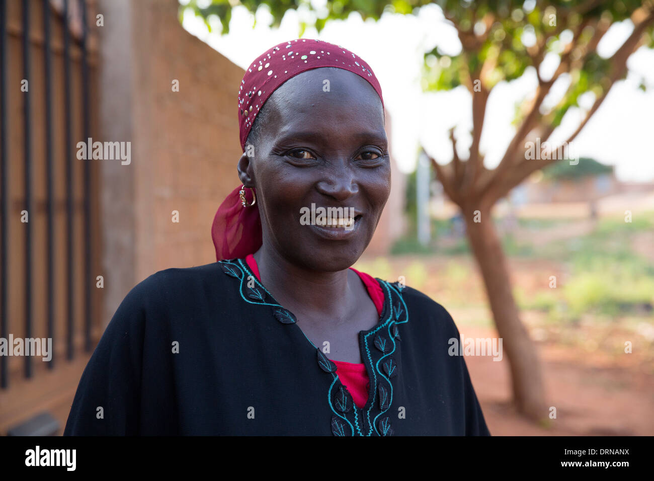 woman standing outside her home in Bobo Dioulasso, Burkina Faso, Africa Stock Photo