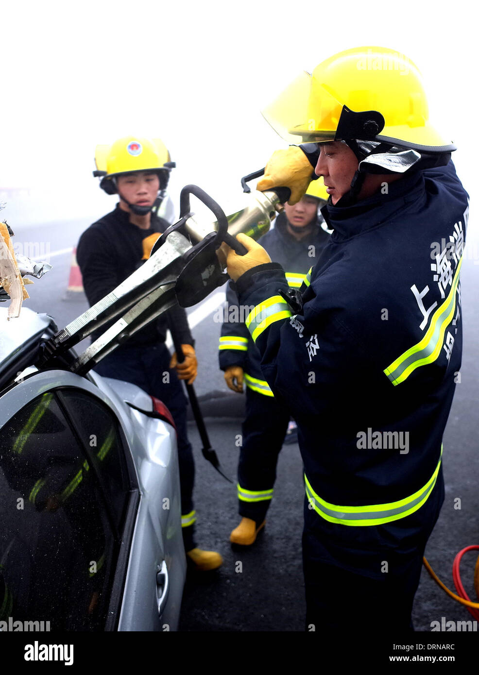 Shanghai, China. 30th January 2014. Firefighters help the trapped get out of a car after a road accident in east China's Shanghai, Jan. 30, 2014. An 11-vehicle pileup happened on the Shanghai-Kunming Expressway Thursday morning. At least three people were killed and 15 others injured, one of whom critically, according to police. Credit:  Xinhua/Alamy Live News Stock Photo