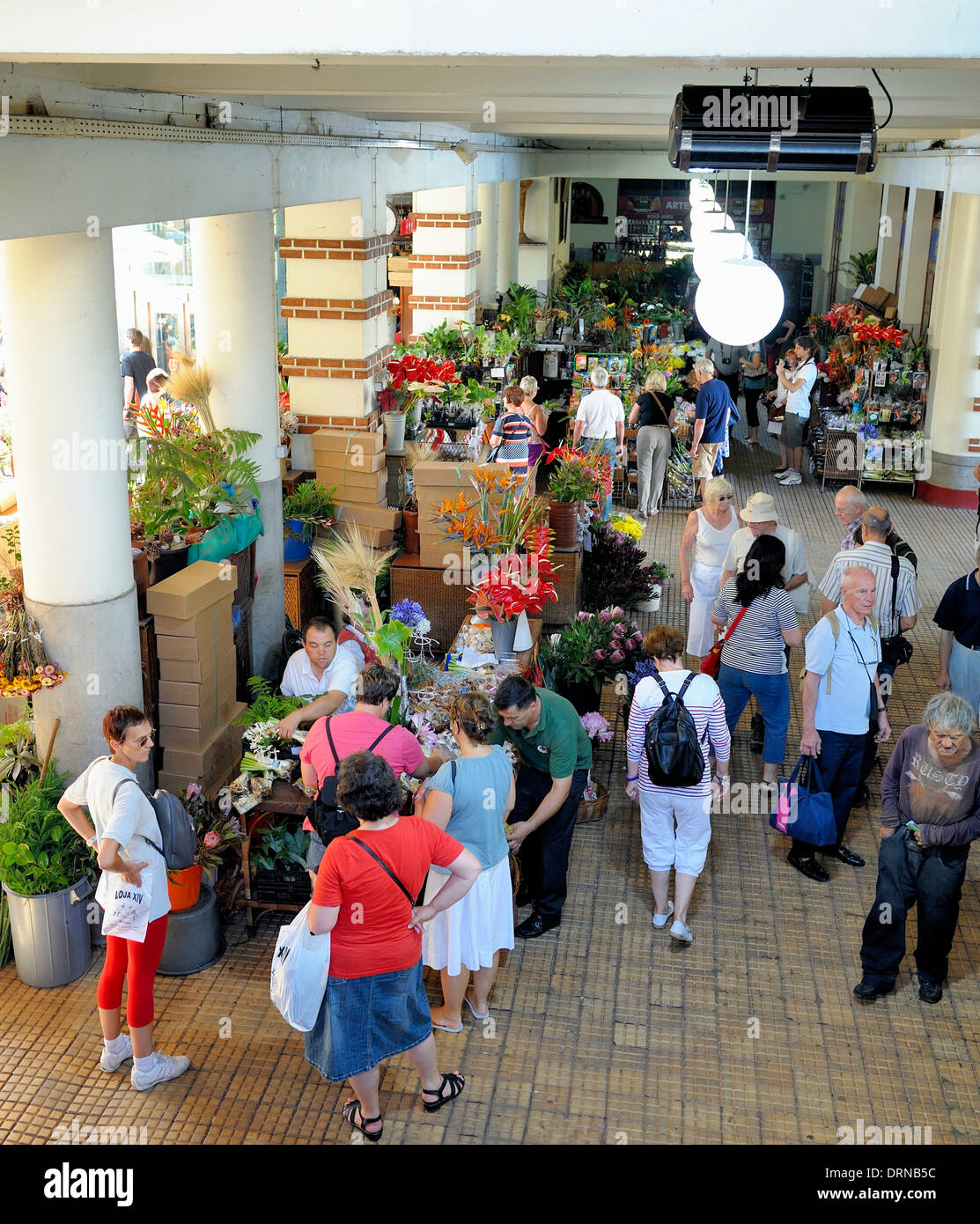 People talking at a indoor flower market stall Funchal Madeira Stock Photo