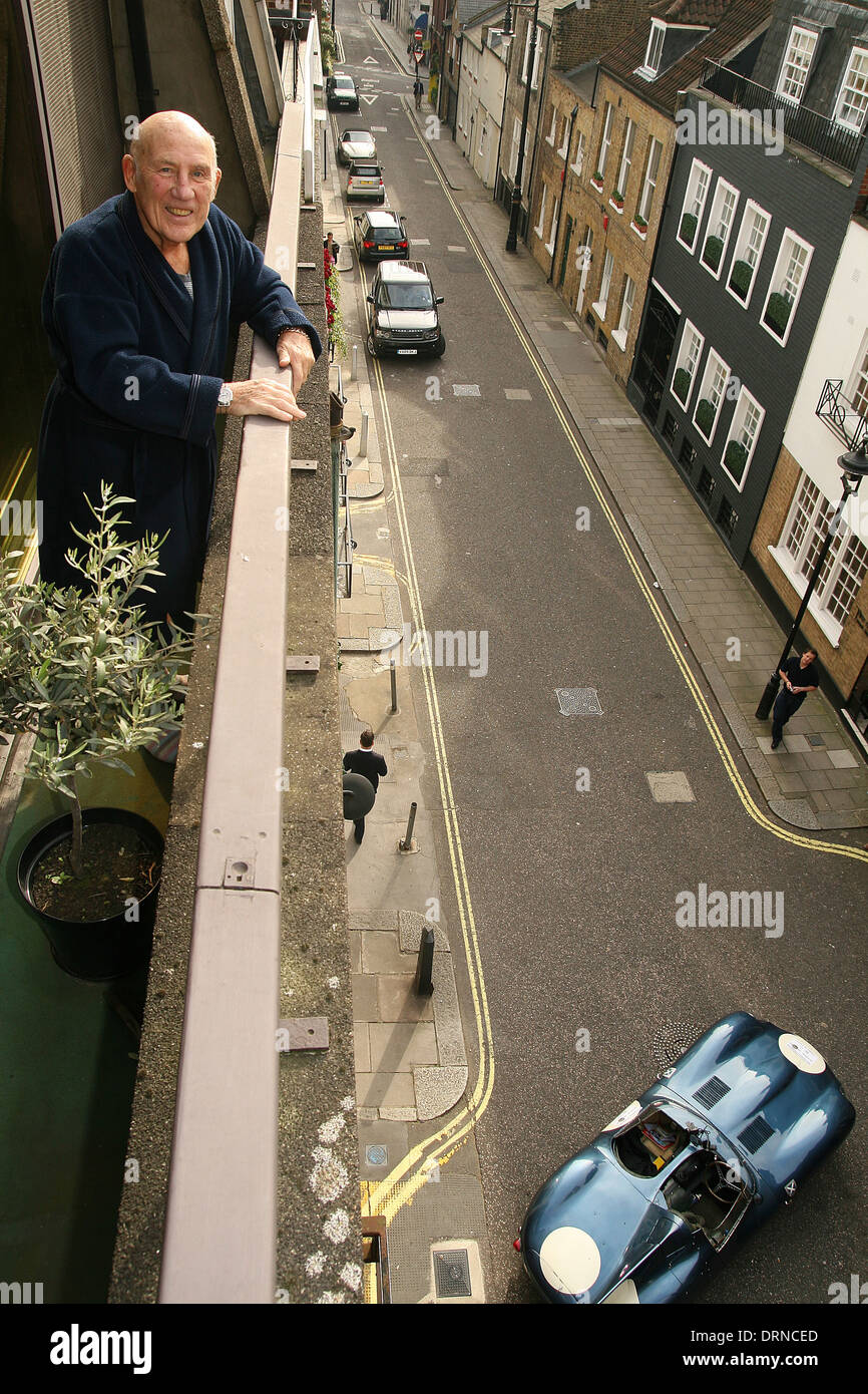 Sir Stirling Moss at home looking over his balcony at a $5m D-type Jaguar in London Stock Photo