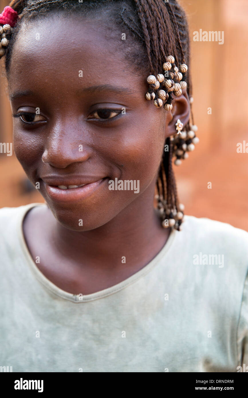 young girl standing outside her home in Bobo Dioulasso, Burkina Faso, Africa Stock Photo
