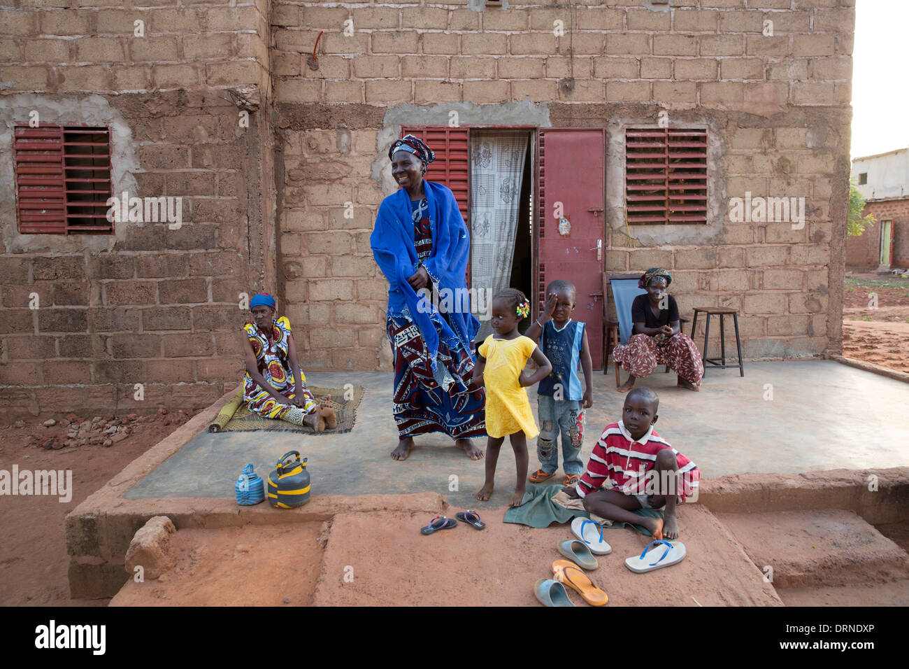 woman standing outside home in Bobo Dioulasso, Burkina Faso, Africa with her children Stock Photo
