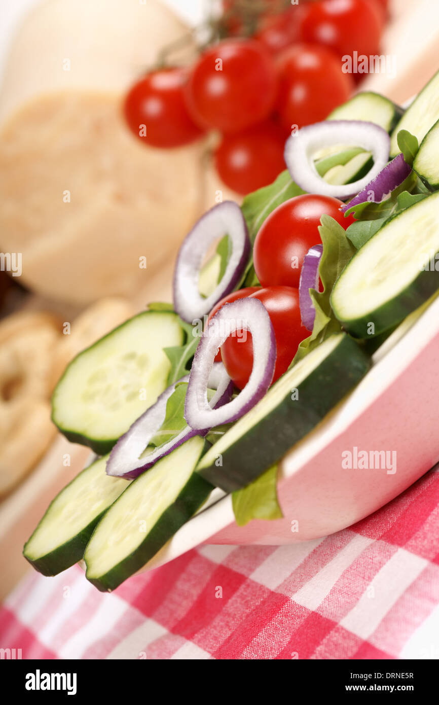 Close-up of a fresh mixed salad served in a dish on a set table. Stock Photo