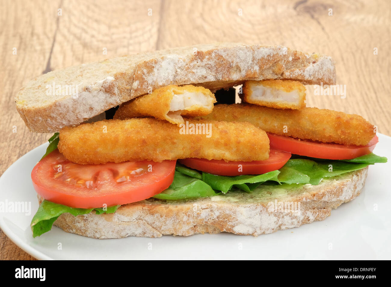 Tasty fish finger stick sandwich with tomato and lettuce - studio shot Stock Photo