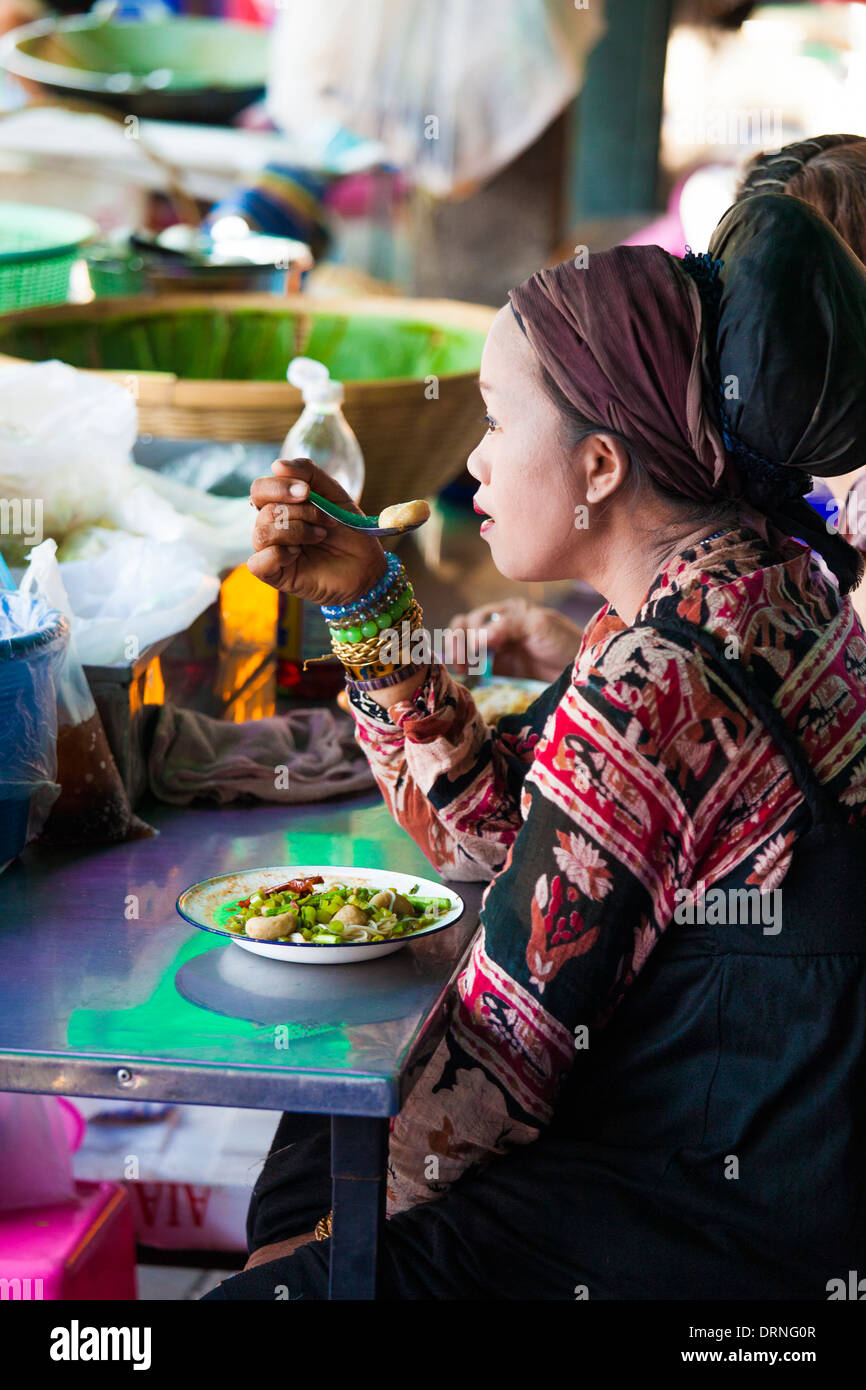 Thai woman eating at a stall in Bangkok, Thailand Stock Photo
