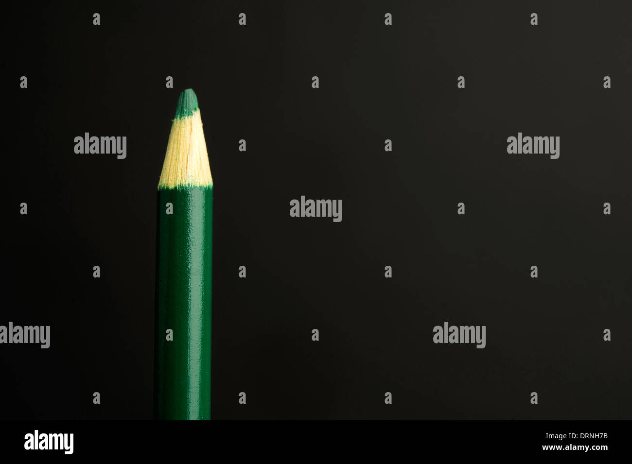 Children's Green pencil crayon on a black background Stock Photo