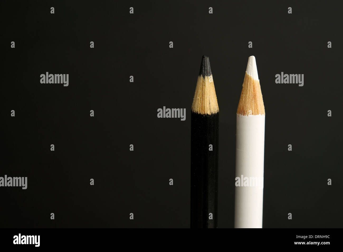 children's black and white coloured pencil crayons on a black background Stock Photo