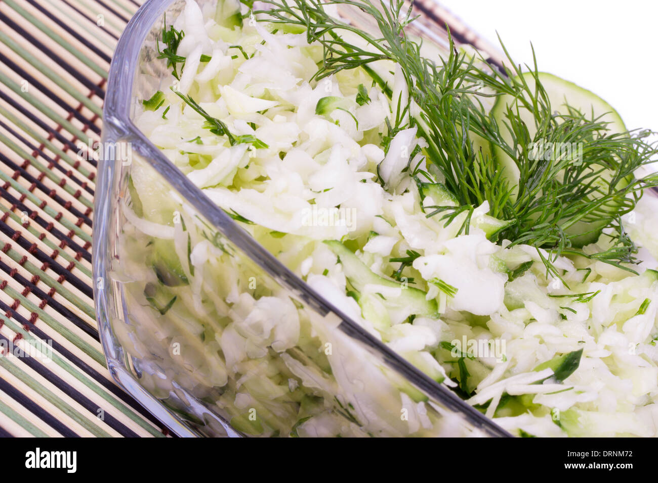 Salad from the crushed cabbage with a cucumber and greens on a wooden ...