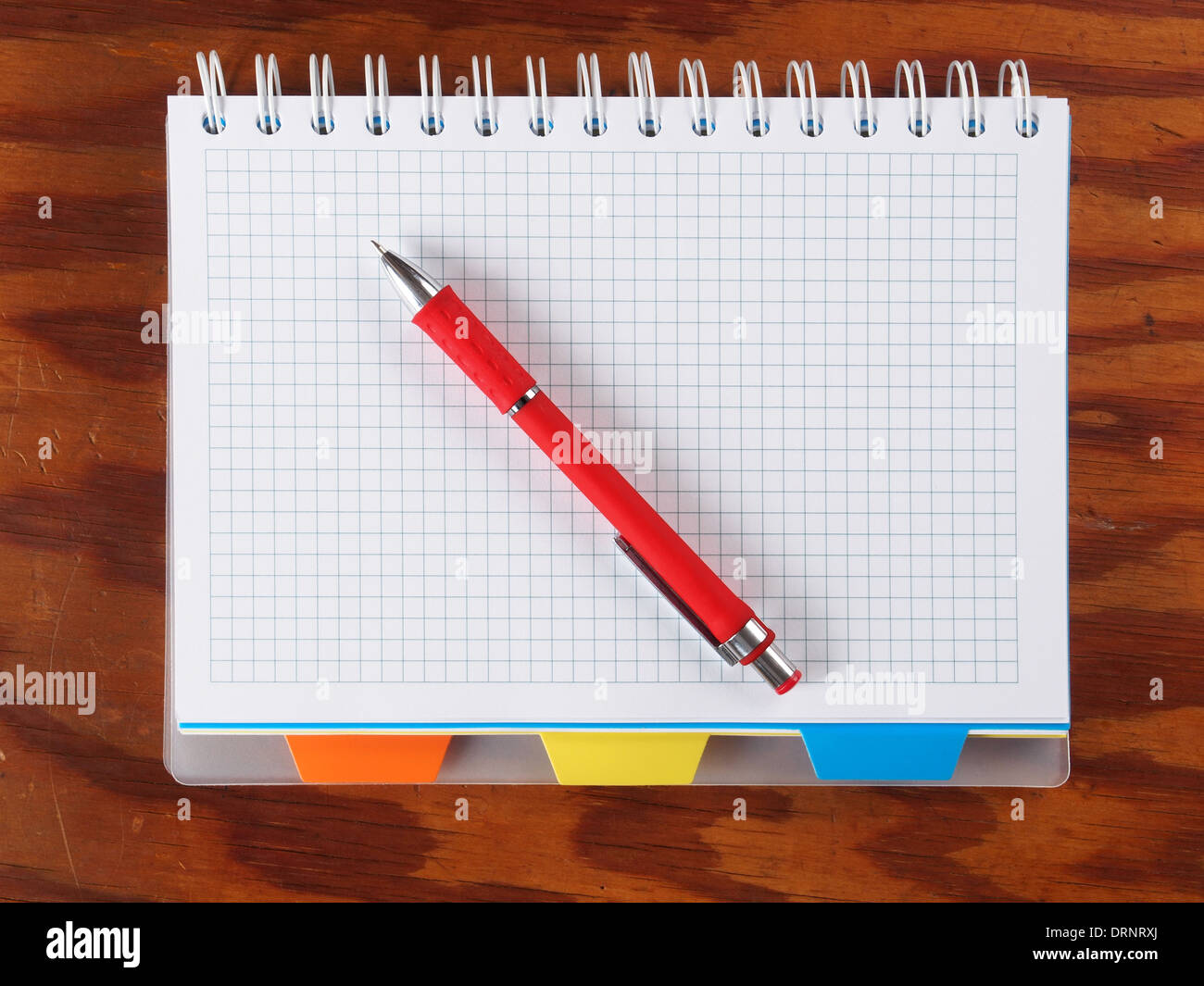 Open blank notebook with red pen on a table. Stock Photo