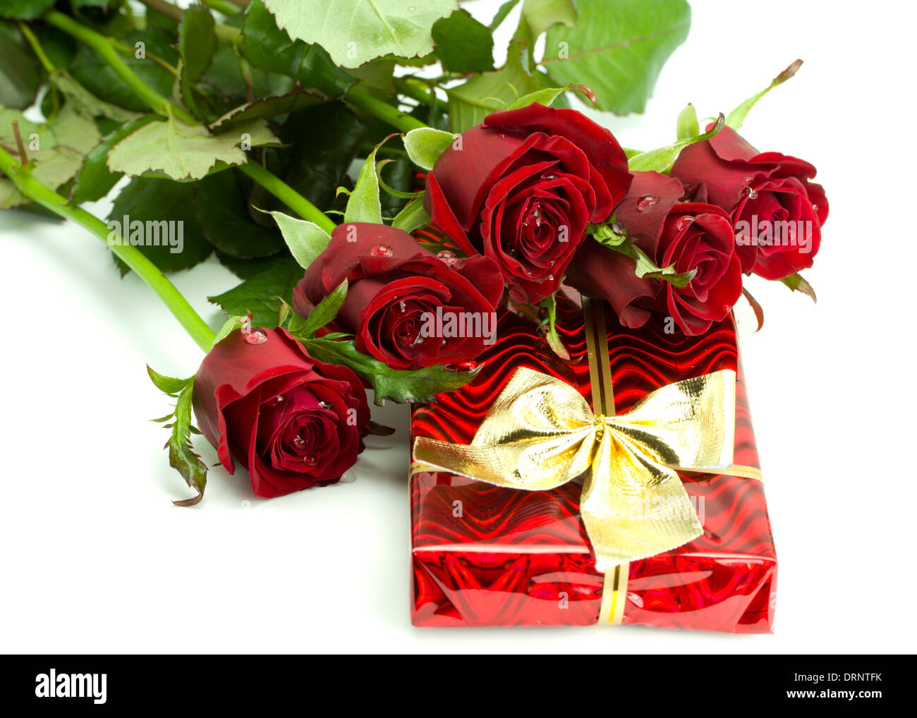 Bouquet of roses and red gift tied up by a bow on the white isolated  background Stock Photo - Alamy