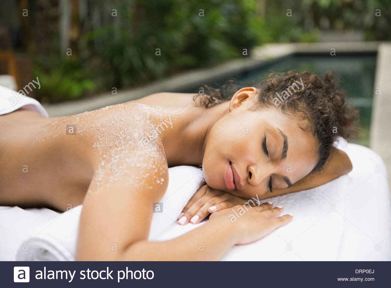 Relaxed woman at day spa receiving body scrub Stock Photo