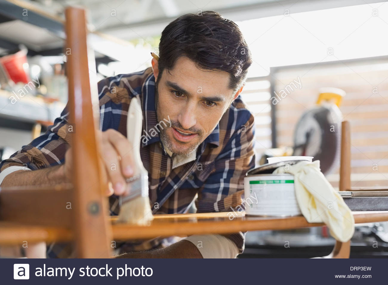 Carpenter staining wood in workshop Stock Photo