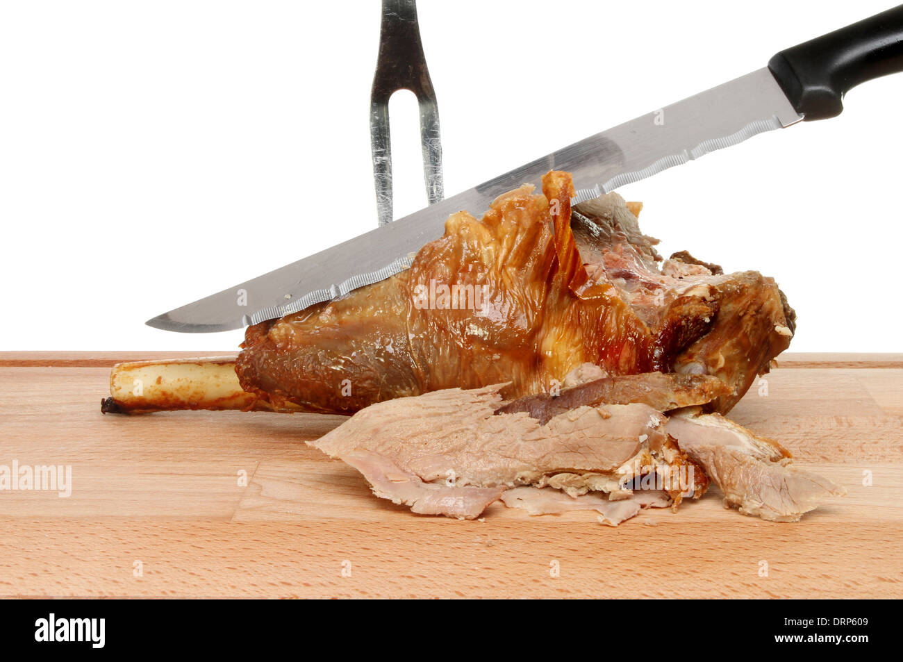 Carving roast leg of lamb joint on a wooden board Stock Photo