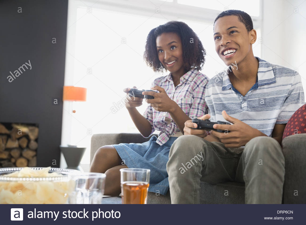 Siblings playing video games at home Stock Photo