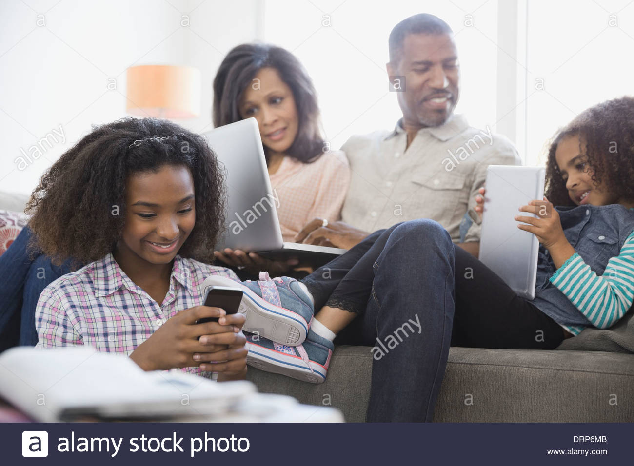 Family using wireless devices at home Stock Photo