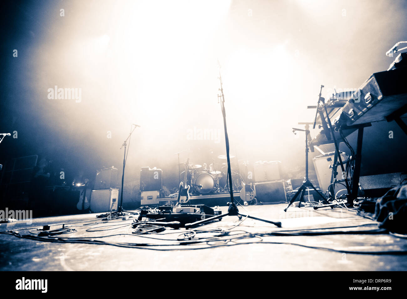Empty illuminated stage with drumkit, guitar and microphones Stock Photo